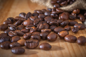 coffee beans and burlap sack on wooden background