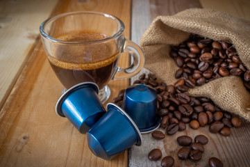 coffee beans and Italian espresso coffee blue capsules pods on a marble background
