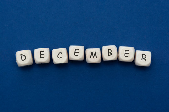 December lettering. Wooden blocks with december word over clasic blue blackground. Copy space.