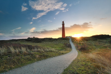 path to red lighthouse at sunrise