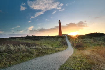 Rolgordijnen path to red lighthouse at sunrise © Olha Rohulya
