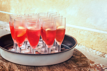 fresh red cocktails, outdoor glasses on a tray placed on a wooden table