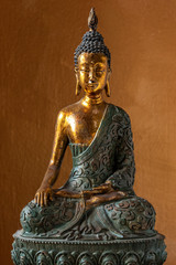 Statue of Wooden Buddha sitting in meditation on orange background