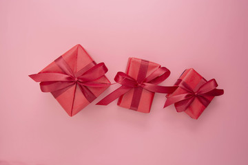 Red gift boxes with ribbon on pink background, flat lay, Valentine's Day, copy space. Frame, border, mock up.