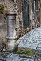 Fototapeta na wymiar Drinking fountain on Coronari street in Rome. Lazio, Italy
