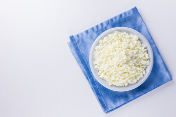 Cottage cheese in a white plate. Fresh cottage cheese on a white background. Homemade curd on a blue napkin in minimalist style. Top view. Copy space