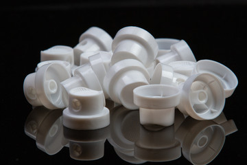close-up of component caps, lids, tubes for aerosol cans and sprayers of chemicals and perfumes. Parts used in the aerosol industry.