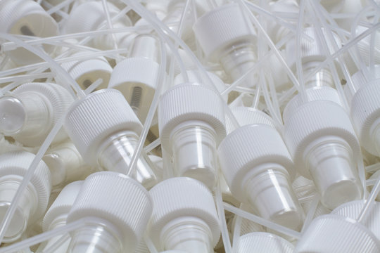 close-up of component caps, lids, tubes for aerosol cans and sprayers of chemicals and perfumes. Parts used in the aerosol industry.