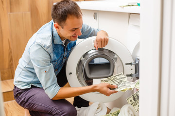 Female putting money into washing machine, closeup