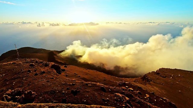 Sunset Timelapse on top of active volcano Stromboli in Sicily with smoke and clouds passing by