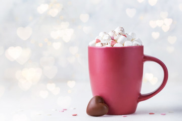 Valentine's day background with bokeh light.  Red cup with cocoa, marshmallows and chocolate candy
