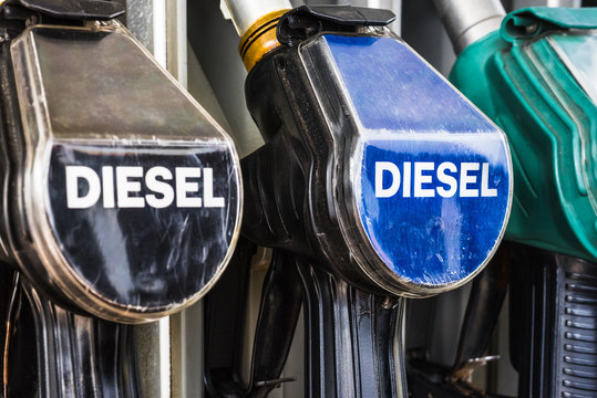 Diesel fuel pistols on a gas station refuelling stand. Detailed macro photo for oil business, truck, airplane and car transportation or ecological theme background