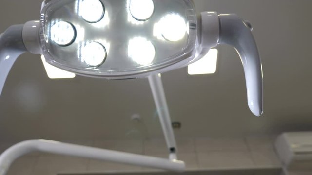 Camera shooting pov from patient. Close-up of dentist hands customizing light. Professional dental lamp in orthondist office. Dentist at work. Modern dentist concept. 4 k