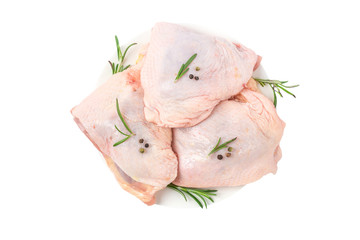 Raw chicken hip meat in a plate with herbs and spices isolated on white background