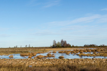 Fototapeta premium Flooded landscape by an old dry stone wall