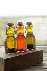 Three bottles of freshly-flavored olive oil with spices.