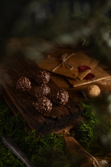 Hazelnut chocolate pralines on dark forest background