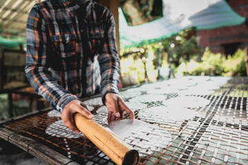 hands of man making rice paper asia