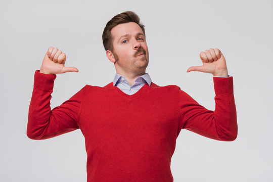 man feeling proud, arrogant and confident, looking satisfied and successful, pointing to self