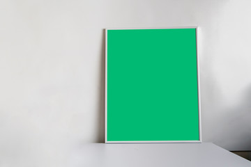 minimalistic style of the picture frame on the shelf, mockup design, green chroma key