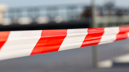 PARIS, FRANCE - December 17, 2019: Close-up of red - white striped plastic tape. Used to shut off areas . E. g. construction sites, crime scenes, areas of danger. Blurry background, 16:9 format