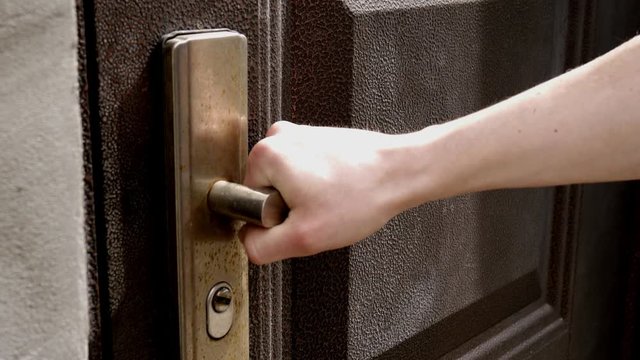 Close up man try to open locked door. Hand pull door handle 