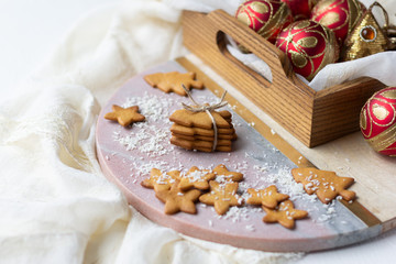 Fototapeta na wymiar Christmas and New Year cookies in shape of Christmas tree and star and baubles in wooden tray. Festive decoration