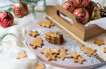 Christmas and New Year cookies in shape of christmas tree and star and baubles in wooden tray. Festive decoration