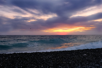 Obraz premium waves of the ocean surf evening before a thunderstorm. Sunset over the ocean