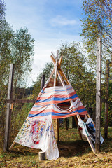 funny tipi or wigwam with handprints in the forest. © Marina Varnava