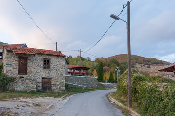 Street in the mountainous Kratero village in Florina, Greece, with old stone houses and Autumn colours