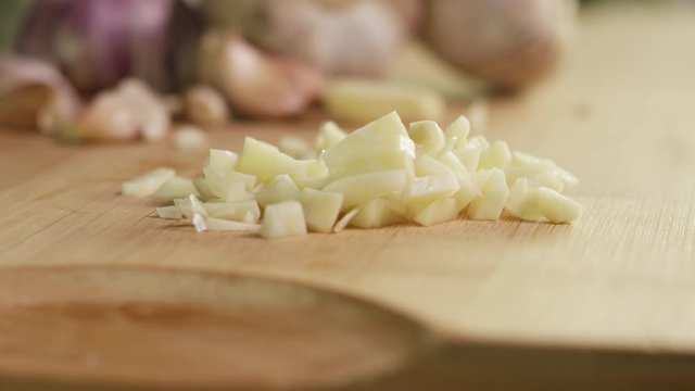 chopped and fresh garlic on wooden board, close up