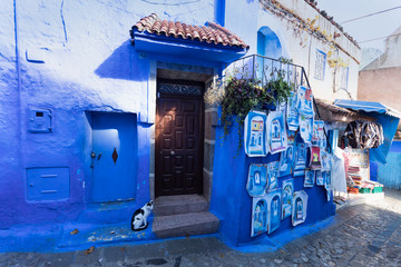 Traditional typical moroccan architectural details in Chefchaouen, Morocco, Africa Beautiful street of blue medina with blue walls and decorated with various objects (pots, jugs). A city with narrow, 