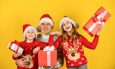 time for presents. happy family celebrate xmas. small girls exchange gifts with father. dad love daughters. bearded santa man with kids. knitted fashion for winter. new year shopping