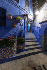 Fototapeta na wymiar Traditional and typical moroccan architectural details in Chefchaouen, Morocco Africa Narrow and beautiful street of blue medina with blue walls and decorated with various objects. Nice doors, windows