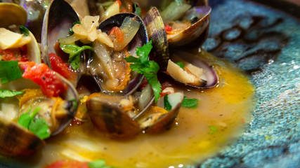 Fototapeta na wymiar Steamed clams in garlic white wine broth