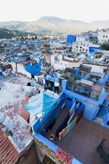 Traditional typical moroccan architectural details in Chefchaouen, Morocco, Africa Beautiful street of blue medina with blue walls and decorated with various objects (pots, jugs). A city with narrow, 