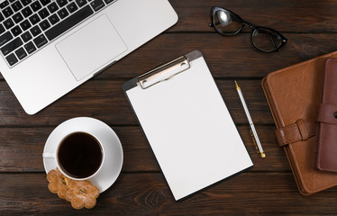 laptop, coffee notepads on wooden background