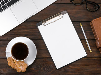 laptop, coffee notepads on wooden background