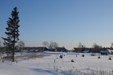 Snow-covered village. Frosty morning. Bright blue sky