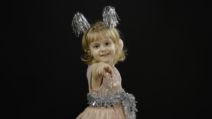 Happy beautiful little baby girl in glossy dress. Christmas. Make faces