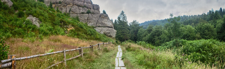 Fototapeta na wymiar Rural landscape, panorama, banner - view of the hiking trail with fence in vicinity of the Tustan medieval fortress, in the Ukrainian Carpathians