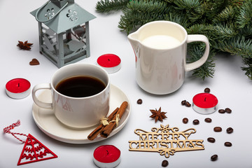 Christmas drink. Cup of espresso coffee with milk, Christmas trees, lantern, red candles and wooden text Merry Christmas. View from above. Selective focus