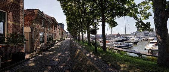 Herengracht street in Muiden town and Vecht river with boat dock, the Netherlands