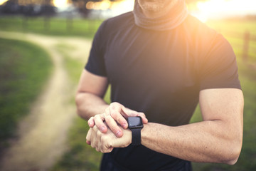 man in black sportswear running down a road in the middle of nature