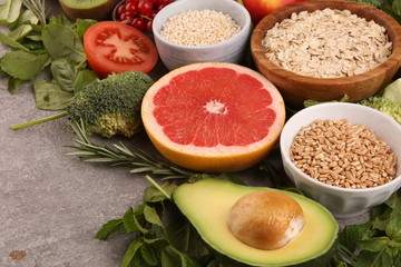 Healthy food clean eating selection: fruit, vegetable, seeds, superfood, cereals, leaf vegetable on rustic background