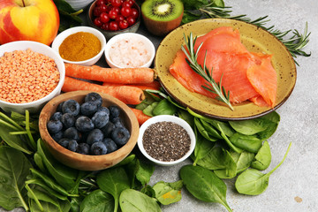 Healthy food clean eating selection: fish, fruit, vegetable, cereal, leaf vegetable on rustic background