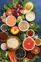 Healthy food clean eating selection: fruit, vegetable, seeds, superfood, cereals, leaf vegetable on rustic background