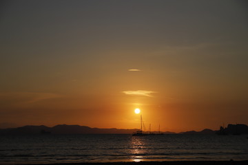 Naklejka na ściany i meble Sunset in the beach with a boat, Thailand 