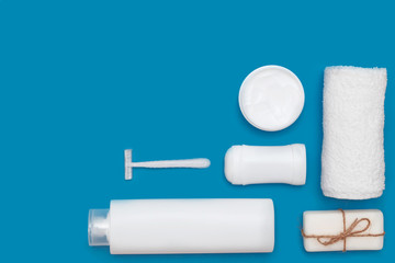 Body and skin hygienic care toiletry products, in white packaging on a blue background. Flat lay. Copy space